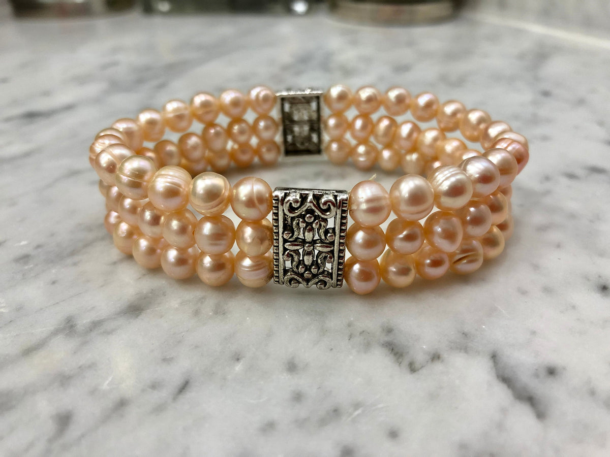 Salmon Colored Freshwater Pearl Stretch Bracelet with Metal Amulets